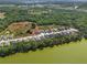 A high aerial view shows single-Gathering homes adjacent to a pond bordered by mature trees at 4545 Fairway Oaks Dr, Mulberry, FL 33860