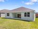 A backyard featuring a covered patio, windows, and a well maintained lawn at 4545 Fairway Oaks Dr, Mulberry, FL 33860