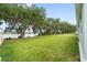 Expansive backyard with mature trees and a view of the tranquil lake at 4545 Fairway Oaks Dr, Mulberry, FL 33860