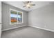 Bright bedroom features a ceiling fan and a large window overlooking the neighborhood at 4545 Fairway Oaks Dr, Mulberry, FL 33860
