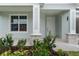 Home's front porch with stone accents, trimmed supports, and professional landscaping at 4545 Fairway Oaks Dr, Mulberry, FL 33860