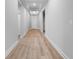 Long hallway featuring wood floors, white trim, recessed lighting, and white doors at 4545 Fairway Oaks Dr, Mulberry, FL 33860