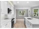 Modern kitchen with white cabinets, stainless appliances, and large window overlooking the water at 4545 Fairway Oaks Dr, Mulberry, FL 33860