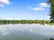 Scenic view of a serene lake surrounded by lush greenery under a blue sky at 4545 Fairway Oaks Dr, Mulberry, FL 33860