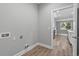 Neat laundry room featuring wood-look flooring and utility connections; kitchen area in view at 4545 Fairway Oaks Dr, Mulberry, FL 33860