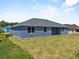 The backyard has an attached patio and large windows to let light in at 4550 Fairway Oaks Dr, Mulberry, FL 33860
