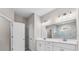 Elegant bathroom with a double sink vanity, modern lighting, and a tiled shower with glass door at 4550 Fairway Oaks Dr, Mulberry, FL 33860