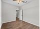 Bedroom with wood flooring, a ceiling fan, and a doorway leading to other areas at 4550 Fairway Oaks Dr, Mulberry, FL 33860