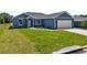 Charming single story home with a blue exterior, attached garage, and green grass at 4550 Fairway Oaks Dr, Mulberry, FL 33860