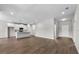 Open-concept living room showcases hardwood floors and seamless flow to the kitchen with modern white cabinets at 4550 Fairway Oaks Dr, Mulberry, FL 33860