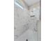 Modern shower featuring marble-patterned tile walls, a niche, hexagon tile floor, and a shower head at 4550 Fairway Oaks Dr, Mulberry, FL 33860