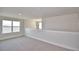 Open-concept room with neutral walls and gray carpet, complemented by natural light and a stylish chandelier at 4646 Grandview Glen Dr, Auburndale, FL 33823