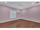 This bedroom offers hardwood floors, a ceiling fan, and natural light from the window at 6487 Ashley Dr, Lakeland, FL 33813
