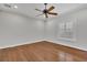 A spacious bedroom with hardwood floors, a ceiling fan, and natural light from the windows at 6487 Ashley Dr, Lakeland, FL 33813