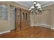 Dining area with hardwood floors, brick accent wall, large cabinet, plantation shutters, and chandelier at 6487 Ashley Dr, Lakeland, FL 33813