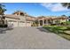 Elegant home featuring a paver driveway, three-car garage, and covered entryway with decorative columns at 6487 Ashley Dr, Lakeland, FL 33813