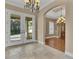 Inviting foyer with tile flooring, chandelier, and an arched entrance to an adjacent dining or living space at 6487 Ashley Dr, Lakeland, FL 33813