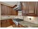 Gourmet kitchen with stainless steel gas cooktop, custom cabinetry, granite countertops and decorative tile backsplash at 6487 Ashley Dr, Lakeland, FL 33813