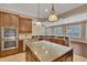 Gourmet kitchen with stainless steel appliances, granite countertops, custom cabinetry, and a spacious island at 6487 Ashley Dr, Lakeland, FL 33813