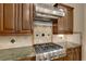 The kitchen features stainless steel gas cooktop, custom cabinetry, granite countertops and decorative tile backsplash at 6487 Ashley Dr, Lakeland, FL 33813