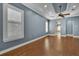 Living room with hardwood floors, tray ceilings, and shuttered windows for natural light at 6487 Ashley Dr, Lakeland, FL 33813