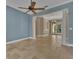 Living room with ceramic tile flooring, ceiling fan, and decorative columns defining the space at 6487 Ashley Dr, Lakeland, FL 33813