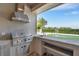 This outdoor kitchen features a built-in grill and bar with views of the backyard at 6487 Ashley Dr, Lakeland, FL 33813