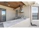 View of a travertine counter in an outdoor kitchen with a stainless steel grill and modern vent hood at 6487 Ashley Dr, Lakeland, FL 33813