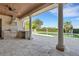 This covered patio features a ceiling fan, an outdoor kitchen, and views of the pool at 6487 Ashley Dr, Lakeland, FL 33813