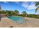 Backyard pool surrounded by lush landscaping and a stone patio at 6487 Ashley Dr, Lakeland, FL 33813