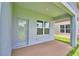 View of covered back patio featuring a back door, window, and concrete flooring at 1484 Leamington Ln, Winter Haven, FL 33884