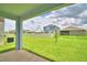 View of fenced backyard and neighboring houses, as seen from a covered patio at 1484 Leamington Ln, Winter Haven, FL 33884