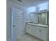Bright bathroom featuring a double vanity with a granite countertop and tiled floor at 1484 Leamington Ln, Winter Haven, FL 33884