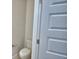 Cozy half bathroom featuring a toilet and neutral-colored walls, adjacent to a partially open door at 1484 Leamington Ln, Winter Haven, FL 33884