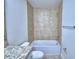 Cozy bathroom showcasing a tiled shower-tub, white fixtures, and granite countertops at 1484 Leamington Ln, Winter Haven, FL 33884