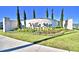Community sign with landscaping, green lawn and trees on a sunny day at 1484 Leamington Ln, Winter Haven, FL 33884