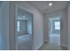 Hallway shows neutral paint, carpeted floor, and doors leading to bedrooms at 1484 Leamington Ln, Winter Haven, FL 33884