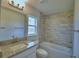 Bathroom featuring granite vanity top, decorative light fixture, and tiled bathtub and shower at 4670 Grandview Glen Dr, Auburndale, FL 33823