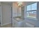 Well-lit bathroom featuring a granite countertop, modern fixtures, and a window offering a view at 4670 Grandview Glen Dr, Auburndale, FL 33823