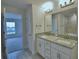 Bathroom featuring double granite vanity and tile flooring, with an open doorway to a bedroom at 4670 Grandview Glen Dr, Auburndale, FL 33823