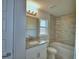 A modern bathroom with a white vanity, granite countertop, and tiled bathtub area at 4670 Grandview Glen Dr, Auburndale, FL 33823