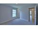 Carpeted bedroom with a large window and neutral walls showcasing entrances to other rooms at 4670 Grandview Glen Dr, Auburndale, FL 33823