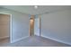 Bright bedroom showcasing neutral walls, plush carpet, and a doorway leading to a walk-in closet at 4670 Grandview Glen Dr, Auburndale, FL 33823