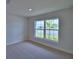 Bright bedroom with a large window offering outdoor views and neutral carpeting at 4670 Grandview Glen Dr, Auburndale, FL 33823
