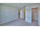 A carpeted bedroom with neutral walls and trim shows openings to a kitchen and a closet at 4670 Grandview Glen Dr, Auburndale, FL 33823