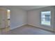 Carpeted bedroom with neutral walls and trim shows an opening to a bathroom and a window at 4670 Grandview Glen Dr, Auburndale, FL 33823