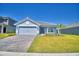 Charming single-story home with a well-manicured lawn, brick driveway, and a two-car garage at 4670 Grandview Glen Dr, Auburndale, FL 33823