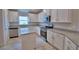 Modern kitchen featuring white cabinets, stainless steel appliances, granite countertops, and wood-look tile flooring at 4670 Grandview Glen Dr, Auburndale, FL 33823