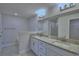 Bathroom featuring dual sinks, granite countertop, a large mirror and shower in the background at 4938 Vue Delac Pass, Auburndale, FL 33823