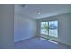 Cozy bedroom featuring neutral carpet, bright natural light, and view of neighborhood at 4938 Vue Delac Pass, Auburndale, FL 33823